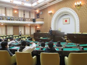 議場で議長の話を聴く児童の皆さんの写真