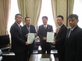 海外行政調査団から議長へ報告書を渡している写真