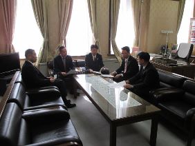 海外行政調査団から正副議長へ報告している写真
