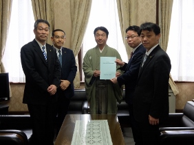 海外行政調査の報告書を議長に提出している様子