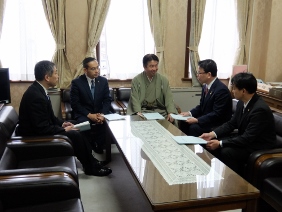 海外行政調査の報告書を議長に提出している様子